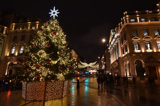 A lit Christmas tree on a Regent Street corner after rain, the wet road throwing the lights back