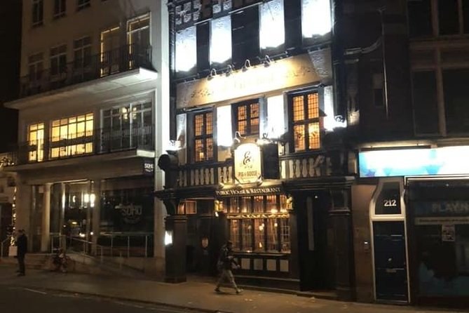 The lit windows of an old pub on an otherwise dark London street at night