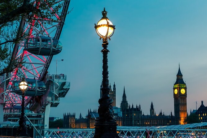 A Victorian street lamp glowing on the Embankment, the London Eye and Big Ben out of focus behind it at dusk